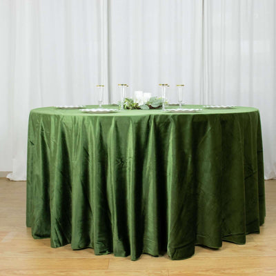Green tablecloth draped over a round table for elegant dining.