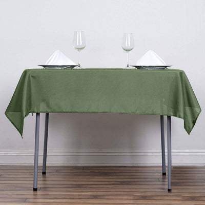 Green tablecloth draped over a table set with plates and glasses.