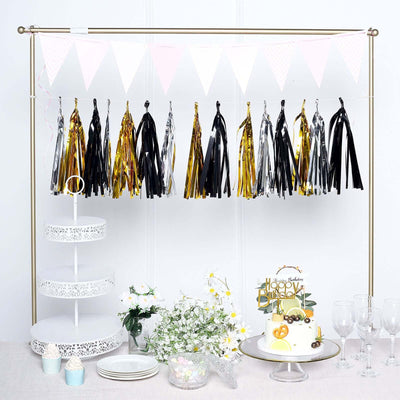 Party decorations with tassels and a cake on a table.