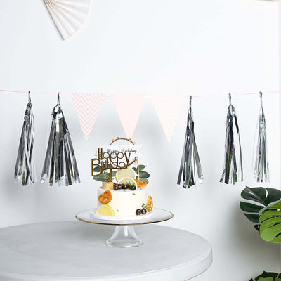 Birthday cake with decorations and silver tassels on a table.