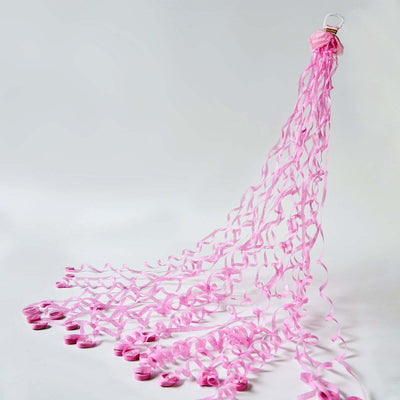 Pink ribbon streamers hanging from a clip, cascading down elegantly.