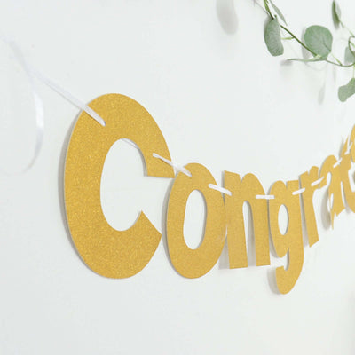 Gold "Congratulations" banner decor against a white wall.