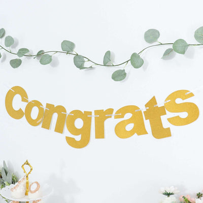Gold "Congrats" banner with greenery backdrop for celebrations.