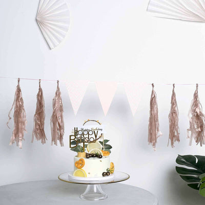 Festive birthday cake with decorative banner and tassels on a white backdrop.