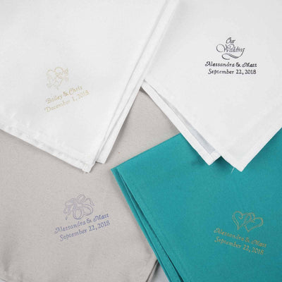 Embroidered napkins in various colors with personalized designs and dates.