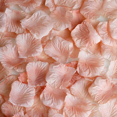 Pink silk rose petals scattered on a surface.