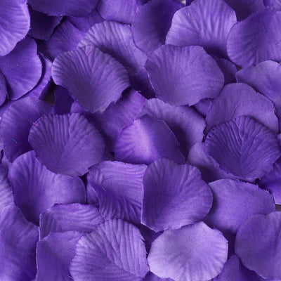 Purple silk rose petals scattered on a surface.
