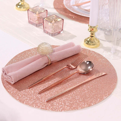 Elegant rose gold table setting with napkin, cutlery, and decorative elements.