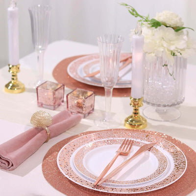 Elegant table setting with rose gold accents, plates, glasses, and floral decor.