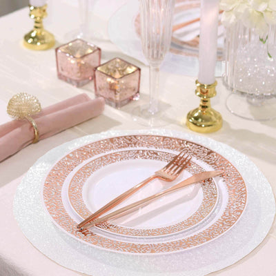 Elegant rose gold cutlery on a decorative plate at a beautifully set table.