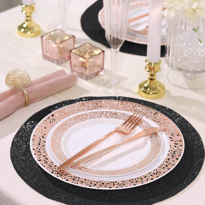 Elegant rose gold and black dinner plate set with cutlery on a festive table setting.