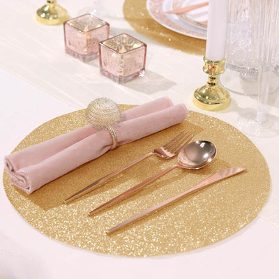 Elegant table setting with gold accents, napkin, cutlery, and decorative candles.
