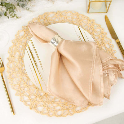 Elegant gold and beige table setting with a napkin on a mirrored plate.