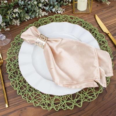 Elegant beige napkin with gold ring on white plate and green placemat.