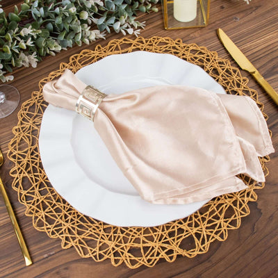 Elegant beige napkin with gold ring on a decorative plate and placemat.