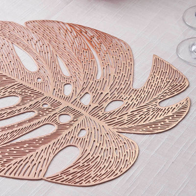 Rose gold leaf placemat with intricate cutout design.