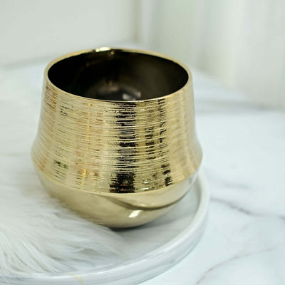 Gold decorative bowl with textured finish on marble surface.