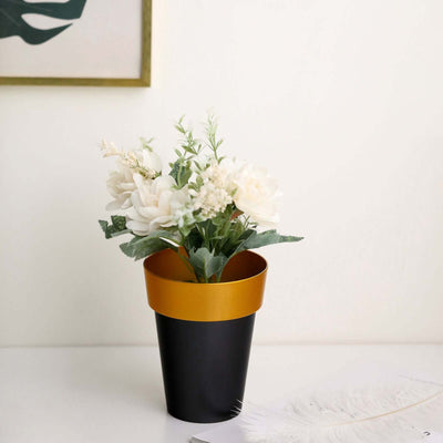 Artificial flower arrangement in a black and gold pot.
