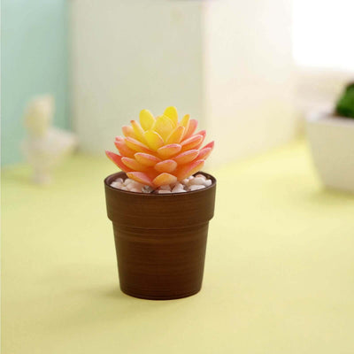 Colorful artificial succulent in a brown pot with decorative stones.