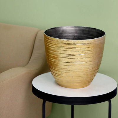 Gold textured bowl on a black side table in a stylish living room setting.