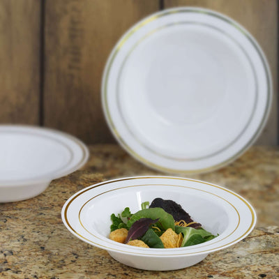 Elegant white salad bowl with gold rim, filled with greens and croutons.