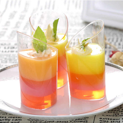 Colorful layered jelly desserts in clear cups garnished with mint leaves.