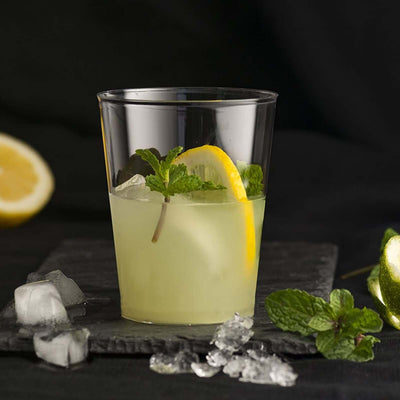 Refreshing lemon mint drink in a clear glass with ice and garnishes.