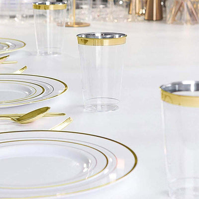 Clear plastic cup with gold rim on a dining table set.