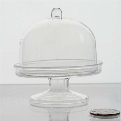 Clear glass cake dome on a pedestal with a coin for scale