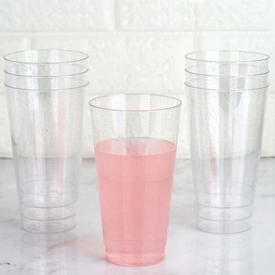 Clear plastic cups with pink drink, stacked and isolated.