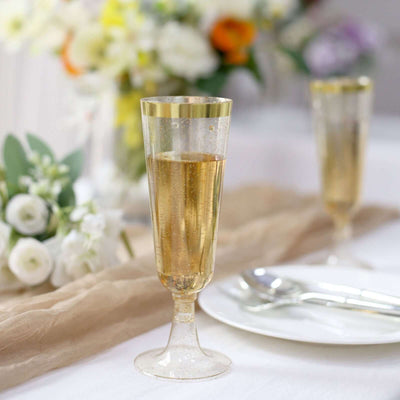 Elegant champagne flutes with gold rims on a table setting.