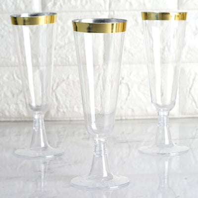 Clear plastic champagne flutes with gold rim, set of three.
