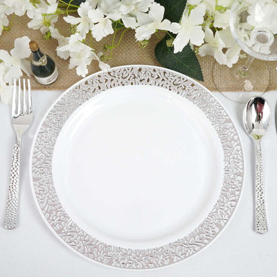 Elegant white plate with intricate silver border, set on a beautifully arranged table.