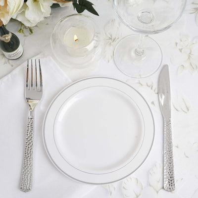 Elegant table setting with silver cutlery and a white plate.