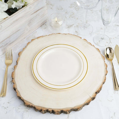 Elegant white plate with gold trim on a rustic wooden table setting.