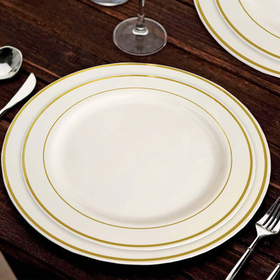 Elegant white dinner plates with gold rim, arranged on a wooden table.