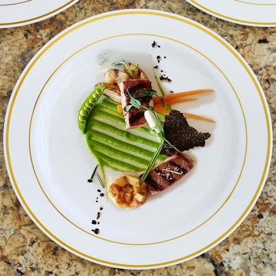 Gourmet plated dish with grilled meat, vegetables, and artistic presentation.