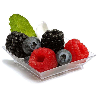 Fresh mixed berries in a clear bowl with mint leaves.