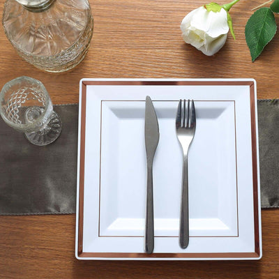 Elegant white dinner plate with knife and fork, set on a wooden table.