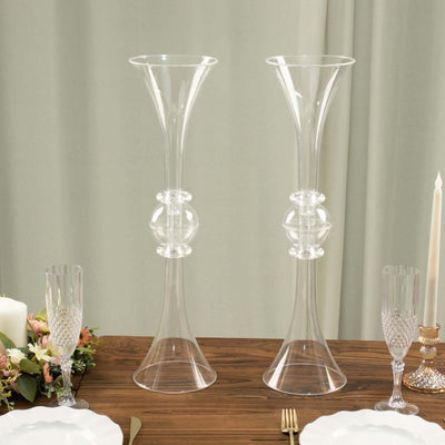 Elegant glass vases with decorative spheres on a dining table.