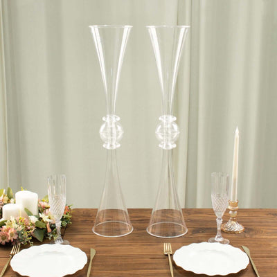 Elegant clear glass vases on a dining table with decorative elements.