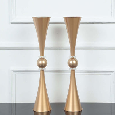 Elegant gold vases with clear accents on a minimalist backdrop.