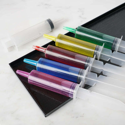 Colorful gelatin syringe set on a tray for fun dessert creations.