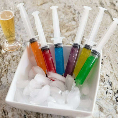 Colorful jelly shot syringes in a bowl of ice.