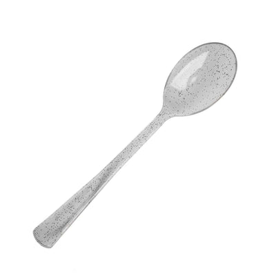 Clear speckled serving spoon on a plain background