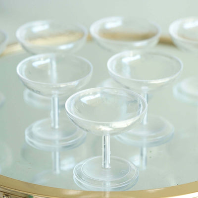 Clear glass dessert cups on a mirrored tray.