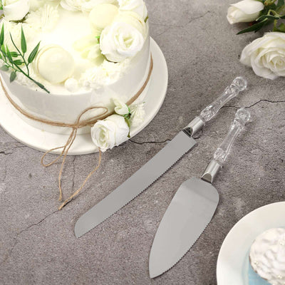Cake serving set with clear handles on a textured surface.