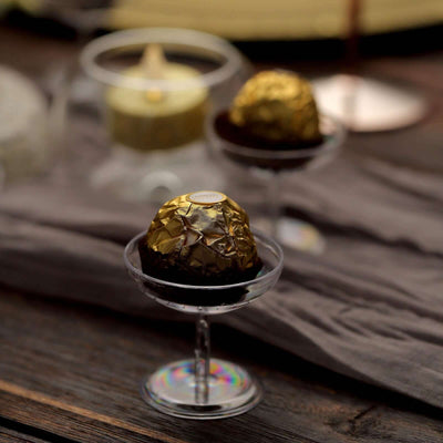 Chocolate truffles in elegant glass dessert cups on a rustic wooden table.