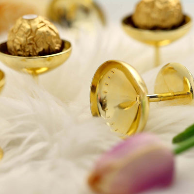 Gold dessert cups with chocolate truffles on a soft white fur background.