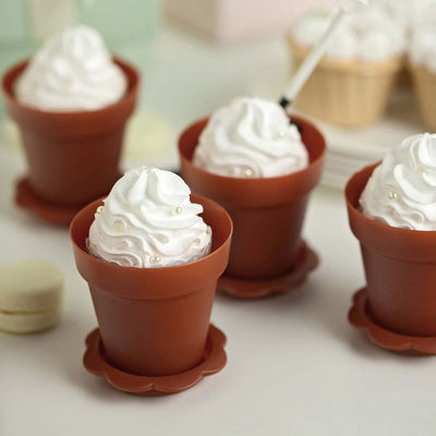 Mini dessert cups with whipped cream and decorative pearls in clay pots.
